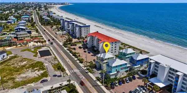 Image 4: Coastal property with direct beach access, multi-story structure, and multiple balconies - Virtually Edited Image