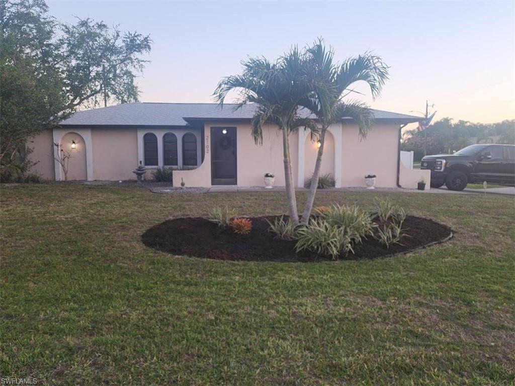 Image 4: Single-story residence featuring a neutral stucco exterior and a gray shingle roof