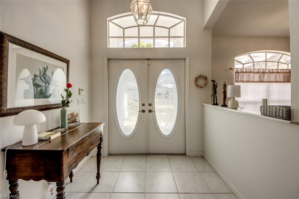 Image 3: Foyer featuring a chandelier, healthy amount of natural light, light tile patterned floors, and french doors