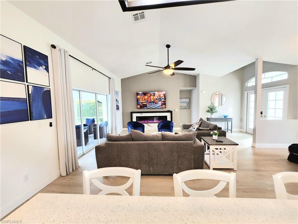 Image 3: Living room with light wood-type flooring, vaulted ceiling, and ceiling fan