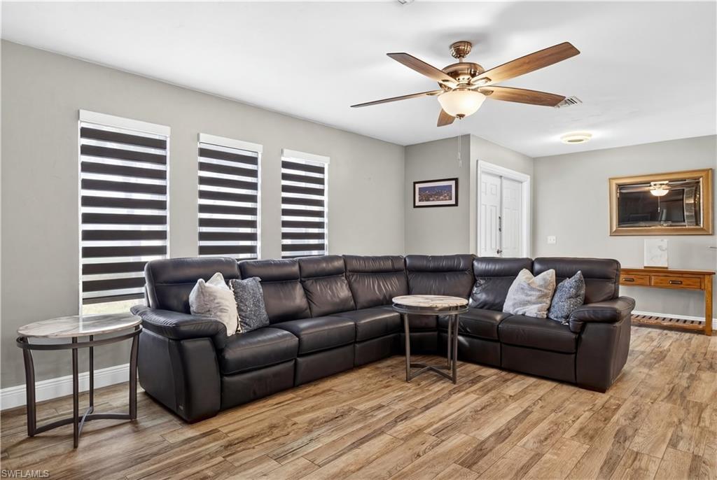 Image 3: Living room featuring light wood-type flooring and ceiling fan