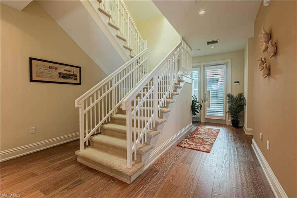 Image 2: Foyer entrance featuring hardwood / wood-style flooring, visible vents, stairs, and baseboards