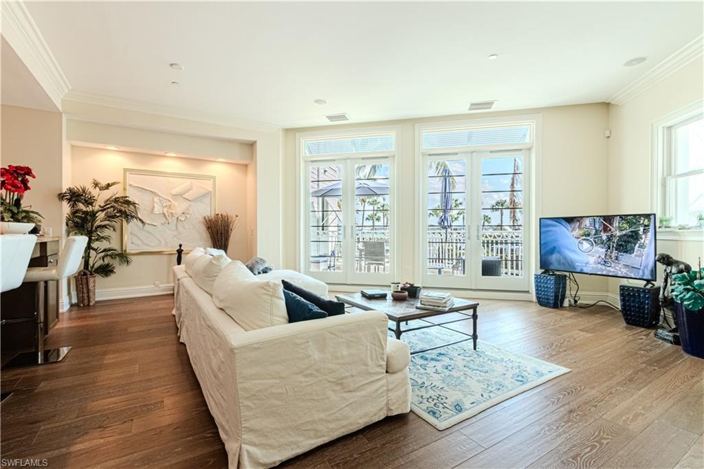 Image 4: Living room with baseboards, wood finished floors, visible vents, and crown molding