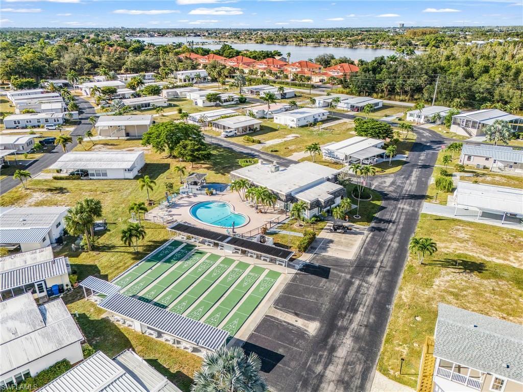Image 4: Aerial view of residential area with a large body of water and a pool area