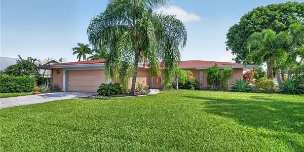 Image 2: Enjoy your lush lawn, complemented by mature trees and shrubs.