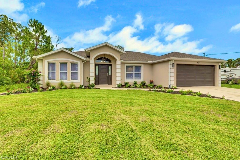 Image 1: Contemporary stucco exterior with a dark brown entry door, arched portico, three-panel bay window, a two-car garage, and a lush green lawn