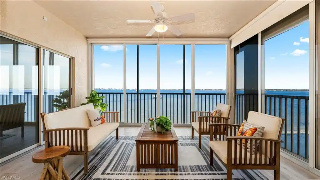Image 1: Sunroom featuring a water view, hardwood / wood-style floors, a textured ceiling, and expansive windows