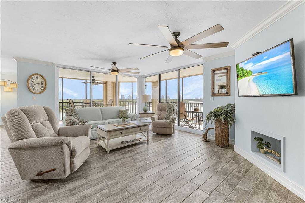 Image 2: The spacious living room has tile that looks like wood, new impact glass sliders that open to the wrap-around lanai.