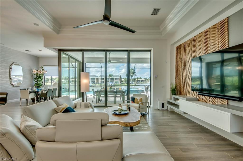 Image 4: Living room with wood tiled floors, a sunroom, a ceiling fan, and crown molding