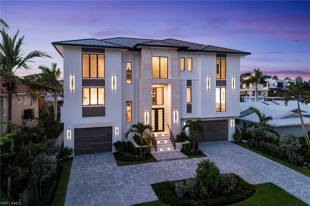 Image 1: Contemporary home featuring a garage, decorative driveway, stucco siding, and a metal roof