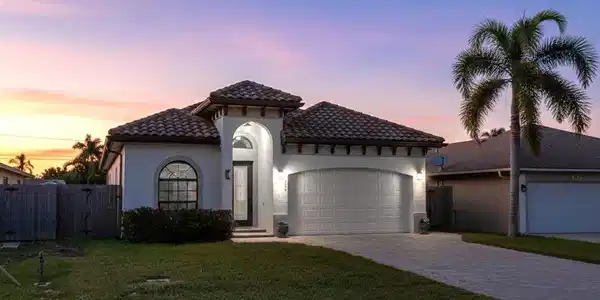 Image 3: Mediterranean / spanish-style home featuring a garage, driveway, a tile roof, and stucco siding