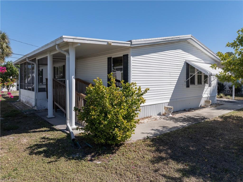Image 2: View of side of home with a sunroom and a lawn