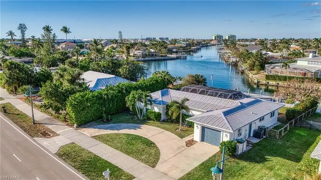 Image 1: Aerial perspective of suburban area featuring a nearby body of water