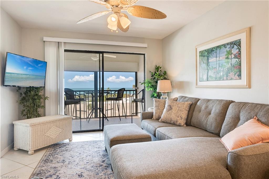 Image 3: Living room with a ceiling fan and tile patterned flooring