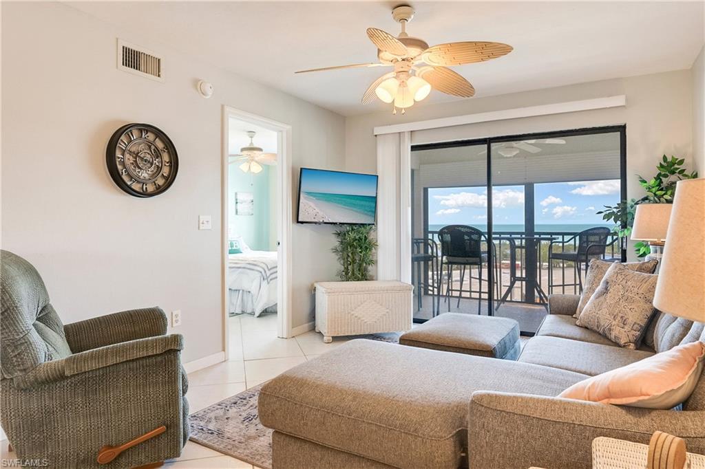 Image 4: Living room featuring light tile patterned floors and ceiling fan