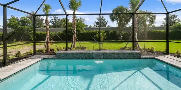 Image 2: Screened-in lanai & pool with raised wall and water feature