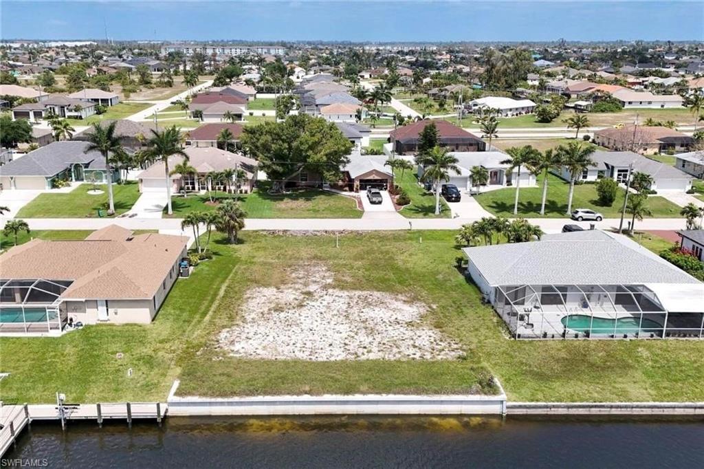 Image 1: Aerial view of residential area featuring a nearby body of water