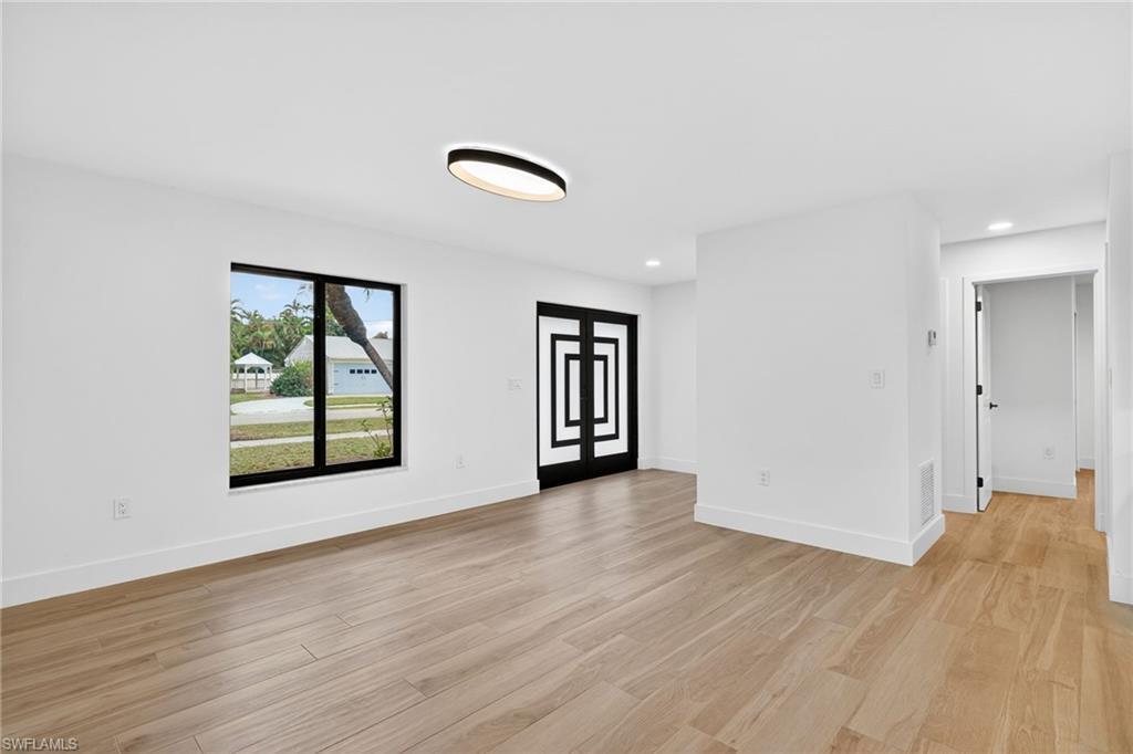 Image 4: Empty room with light wood finished floors and recessed lighting