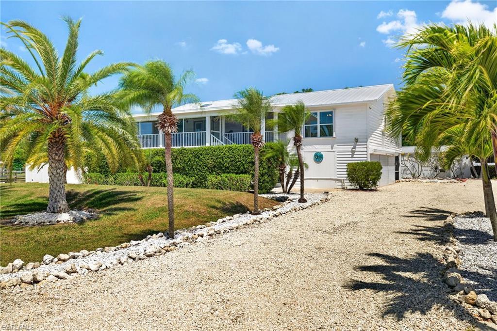 Image 1: Elevated main home with tons of parking space and mature landscaping