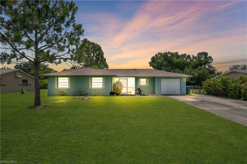 Image 1: Single-story residence featuring a light green exterior and a brown shingle roof
