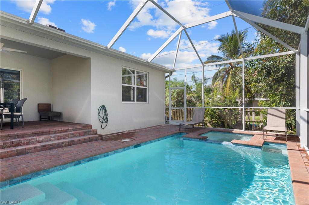 Image 4: View of pool with a patio, glass enclosure, a pool with connected hot tub, and ceiling fan