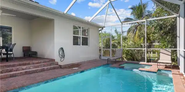 Image 4: View of pool with a patio, glass enclosure, a pool with connected hot tub, and ceiling fan