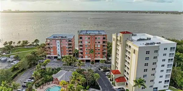 Image 3: Drone / aerial view of apartment complex / building and a nearby body of water