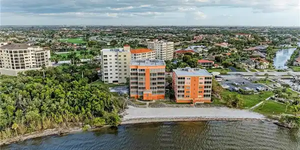 Image 4: Aerial view of a nearby body of water and apartment complex