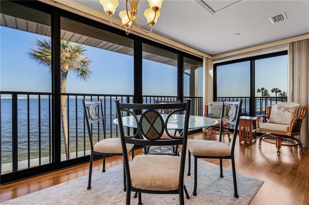 Image 2: Sunroom / solarium with a notable chandelier and a water view