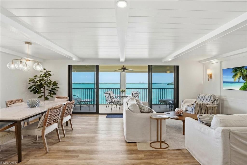 Image 3: Open-concept living space with expansive water views from a private balcony - Virtually Edited Image