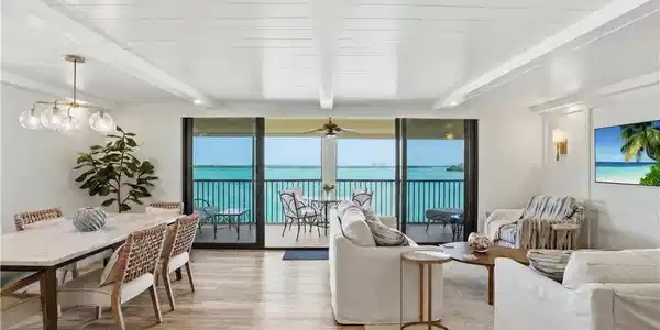 Image 3: Open-concept living space with expansive water views from a private balcony - Virtually Edited Image
