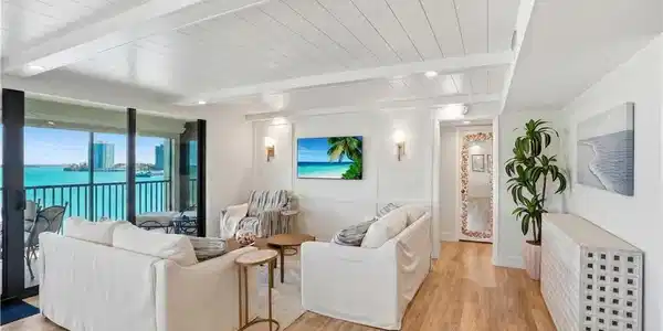Image 4: Living area with wood-finish flooring, shiplap ceiling, recessed lighting, and wall sconces - Virtually Edited Image