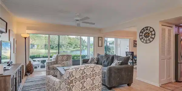 Image 4: Living area with a water view, light wood-type flooring, a ceiling fan, and ornamental molding