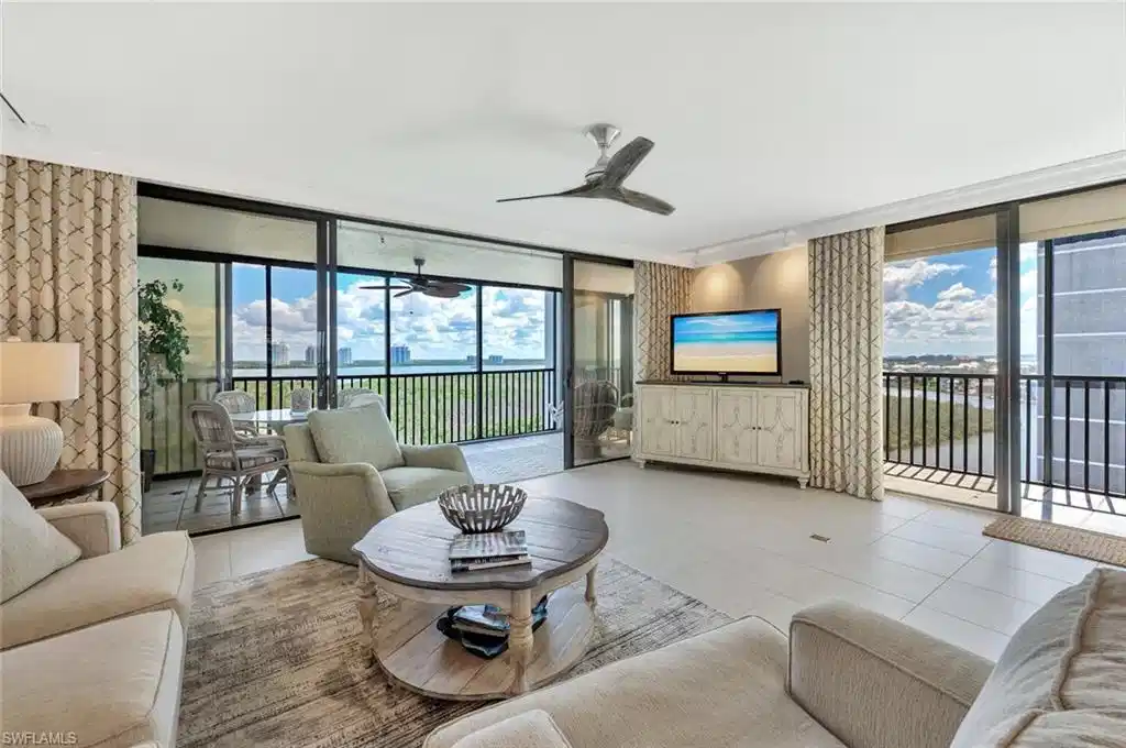 Image 1: Tiled living area with a wall of windows and ceiling fan