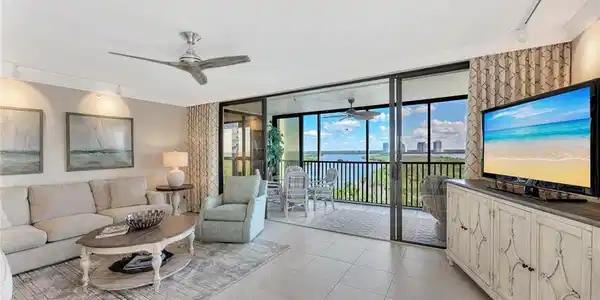 Image 2: Living area featuring rail lighting, expansive windows, ornamental molding, light tile patterned floors, and a ceiling fan