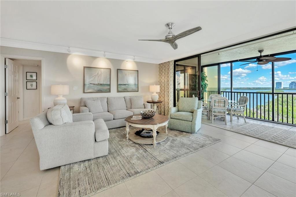 Image 3: Living room featuring a water view, floor to ceiling windows, tile patterned flooring, ceiling fan, and track lighting
