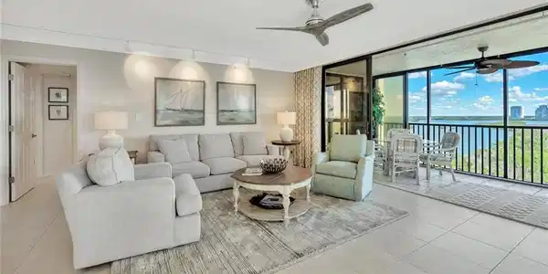 Image 3: Living room featuring a water view, floor to ceiling windows, tile patterned flooring, ceiling fan, and track lighting