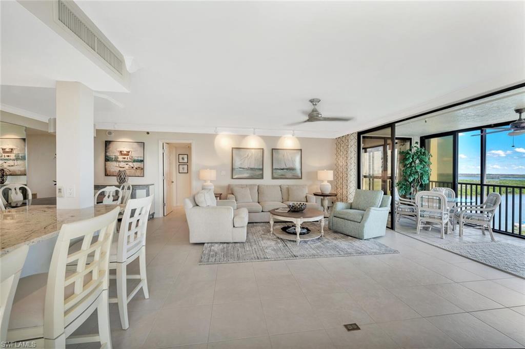 Image 4: Living room featuring a ceiling fan, floor to ceiling windows, light tile patterned floors, and crown molding