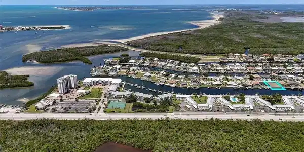 Image 4: Waterfront canal access, expansive water body, residential neighborhood, adjacent green space, clear blue skies