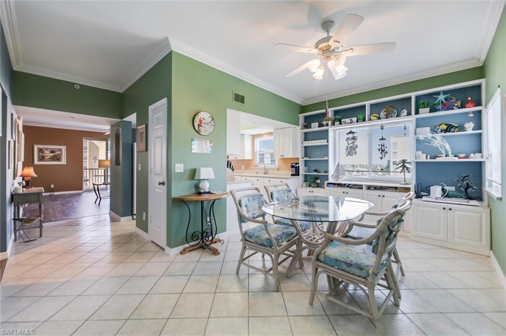 Image 2: Dining room with ornamental molding, light tile patterned flooring, and ceiling fan