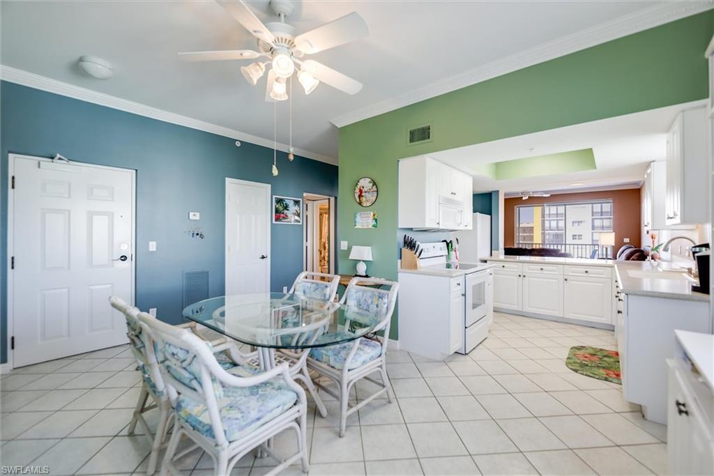 Image 3: Dining area featuring crown molding, light tile patterned flooring, and a ceiling fan