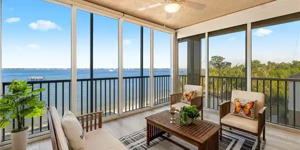 Image 2: Sunroom featuring floor to ceiling windows, hardwood / wood-style flooring, a water view, and a textured ceiling
