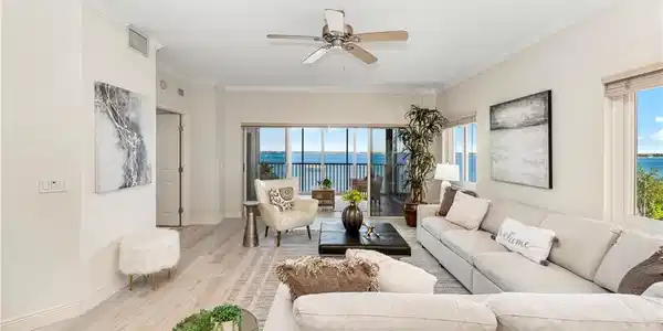 Image 3: Living room featuring wood finished floors, ornamental molding, a water view, ceiling fan, and plenty of natural light