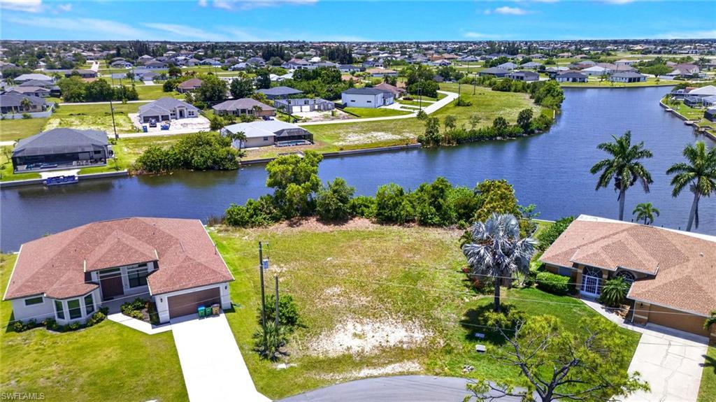 Image 4: Expansive vacant lot featuring a cleared building envelope, waterfront access, and surrounding residential properties