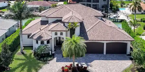 Image 2: View of front of home with a tile roof, decorative driveway, an attached garage, and stucco siding