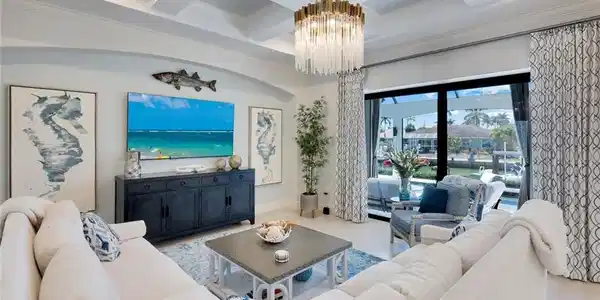 Image 4: Living area with coffered ceiling, ornamental molding, and a chandelier