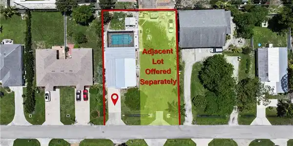 Image 4: Property parcel featuring a paved driveway, a rectangular swimming pool, and a well-maintained lawn