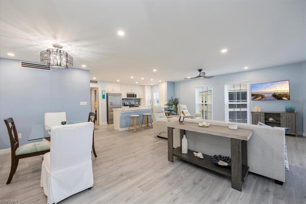 Image 4: Living room with recessed lighting, light wood-style flooring, ceiling fan, and a chandelier