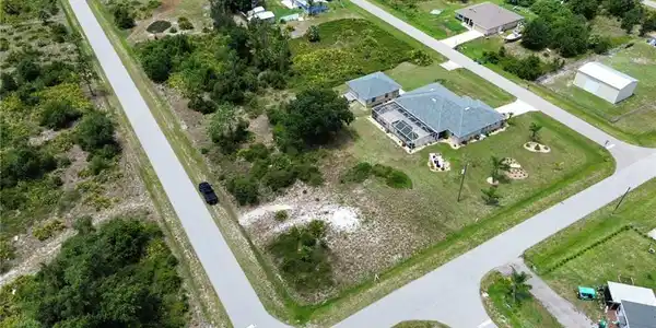 Image 2: Expansive corner lot featuring a single-story residence with an attached garage and a detached accessory structure