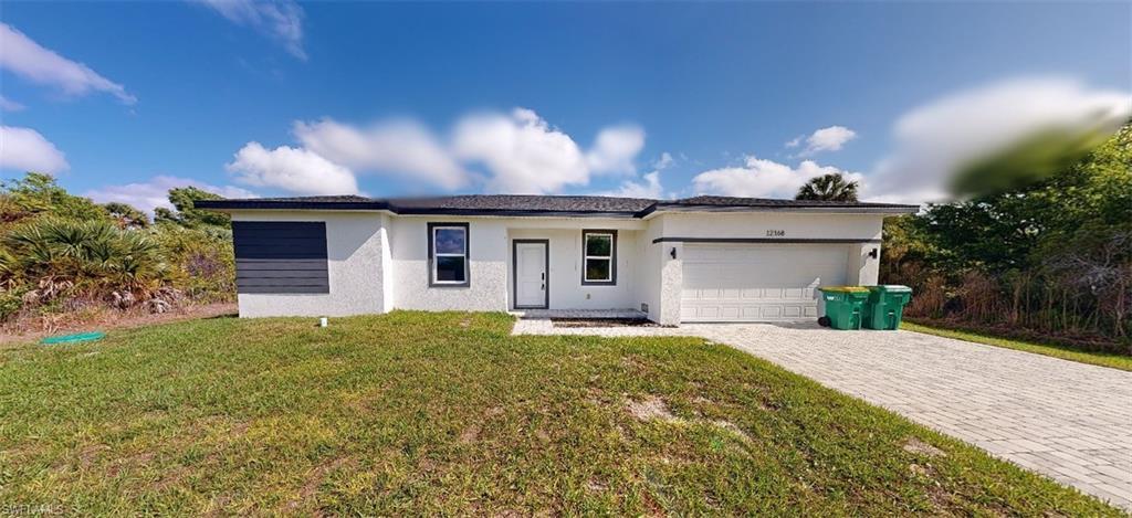 Image 1: Ranch-style house with a front lawn, stucco siding, an attached garage, and decorative driveway
